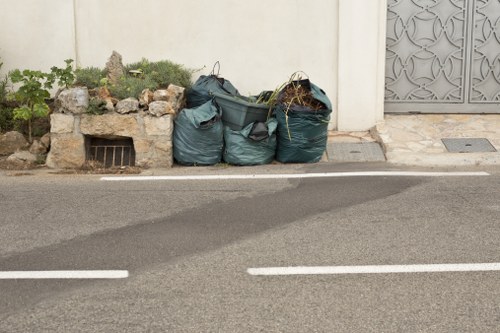 Workers collecting garden waste and sorting for removal